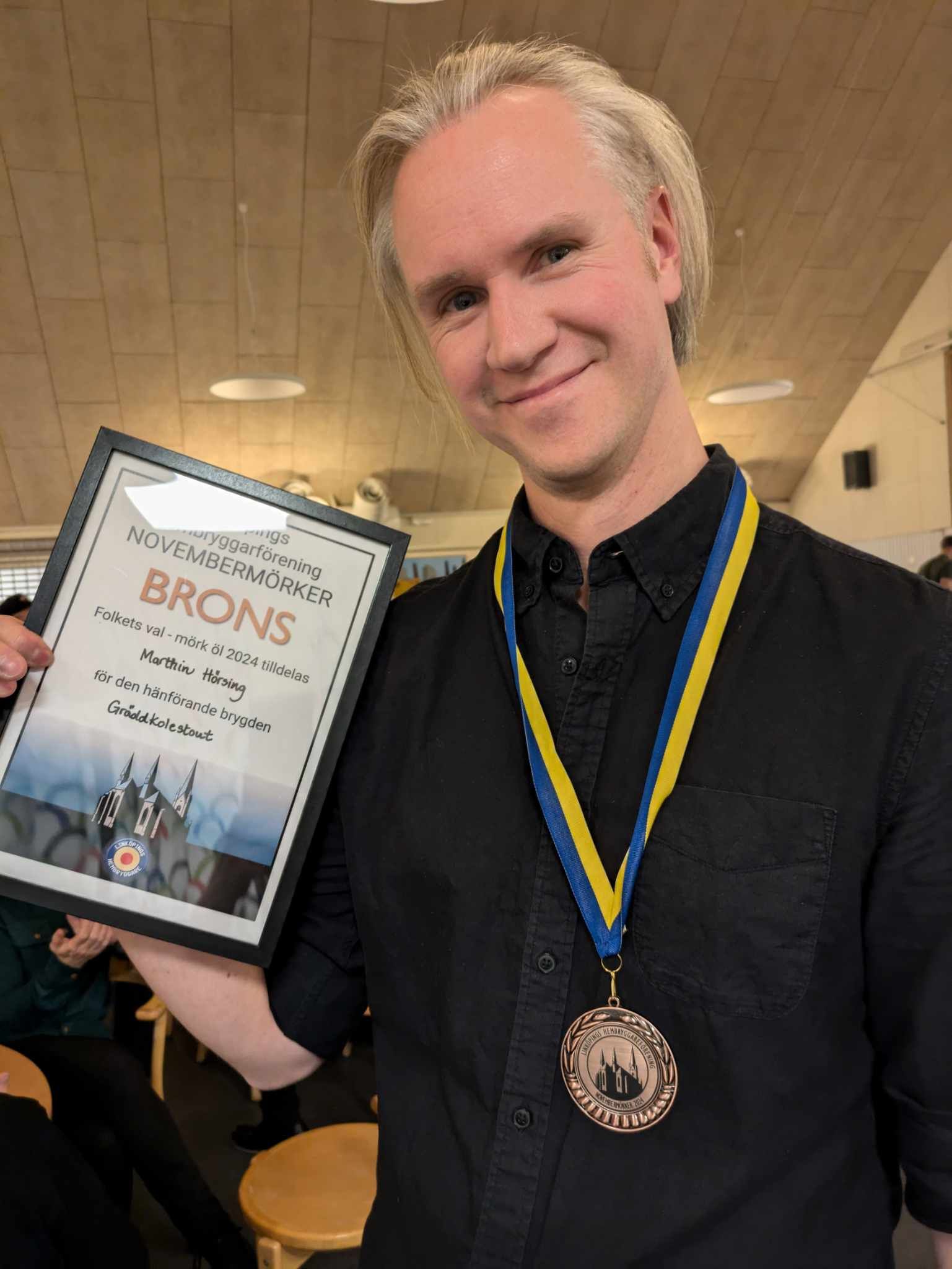 Vår bryggmästare Marthin håller i sitt diplom för brons i Folketsval på Linköpings hembryggareförenings hösevenemang.