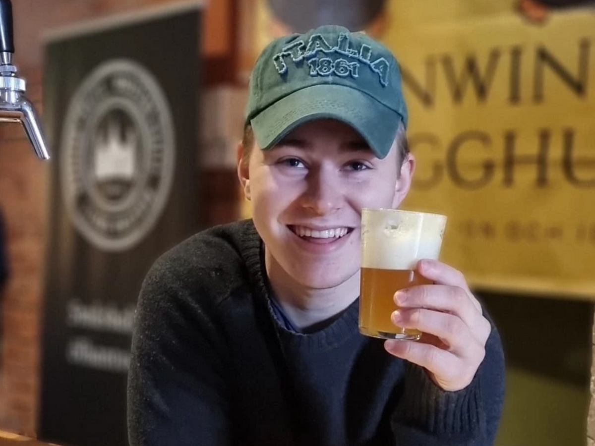 Oscar Hörsing står och håller i ett glas öl från Pinwin och ler in i kameran.